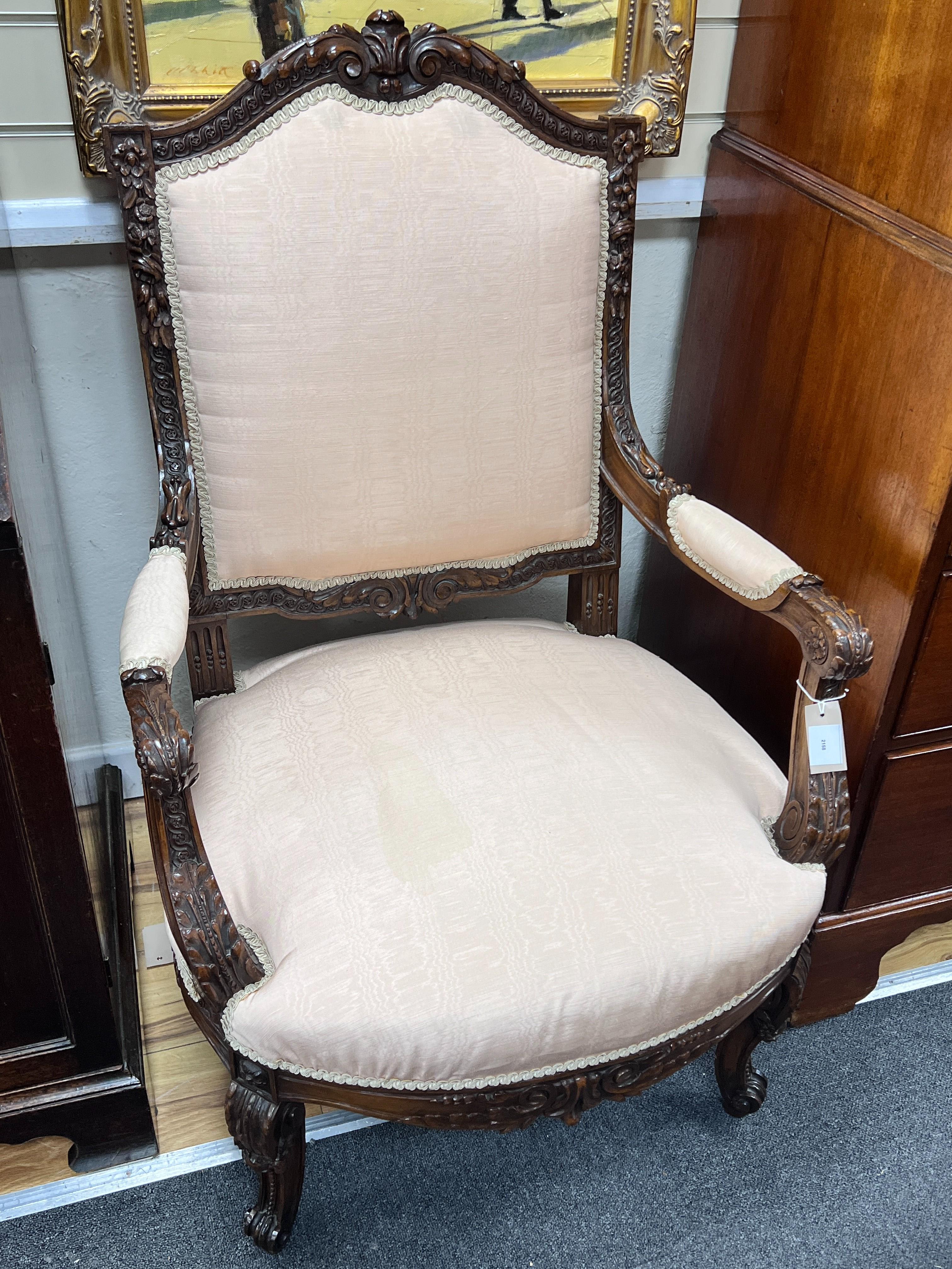 A pair of early 20th century carved walnut upholstered open armchairs, width 67cm, depth 57cm, height 107cm